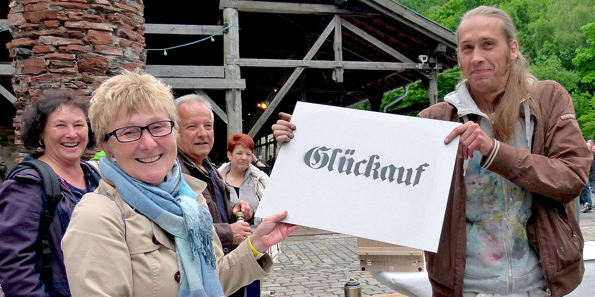 Ein neues Graffiti von Jonas Heinevetter (r.) ziert die Stockumer Mehrzweckhalle an der Pferdebachstraße. Der Wittener Graffitikünstler erweckte auch bei Besuchern der Extraschicht die künstlerische Ader. (Foto: Marek Schirmer)